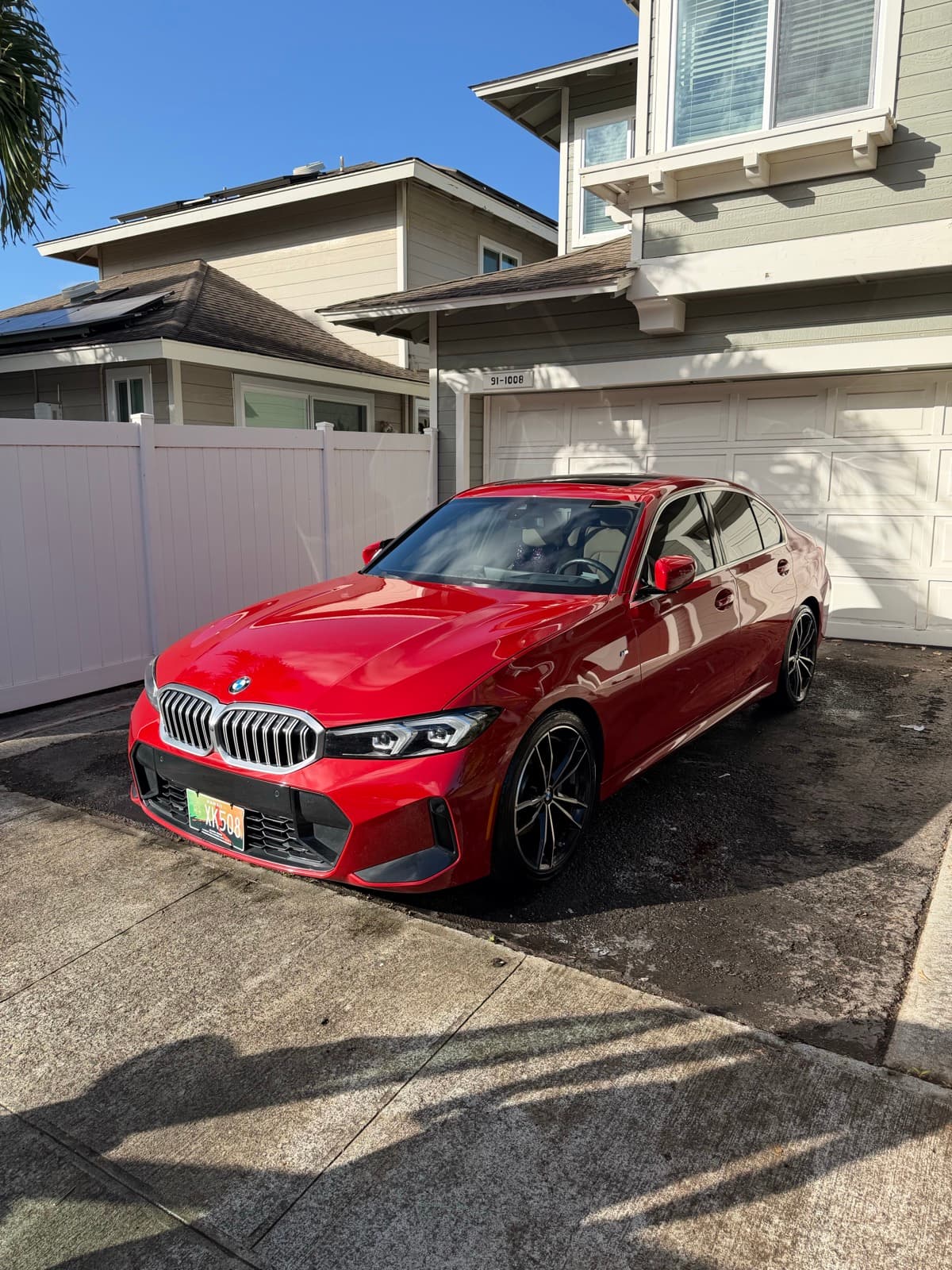 Red BMW coupe exterior detail in residential driveway — Mililani, Oahu Hawaii