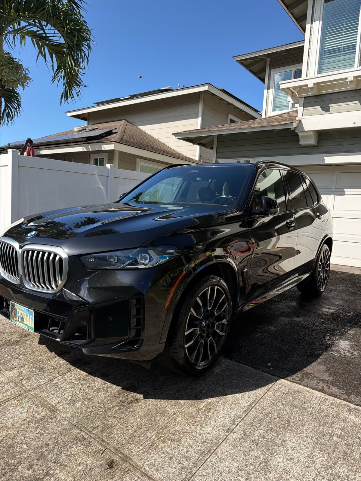 Black BMW exterior detail in tropical residential driveway — Kapolei, Oahu Hawaii