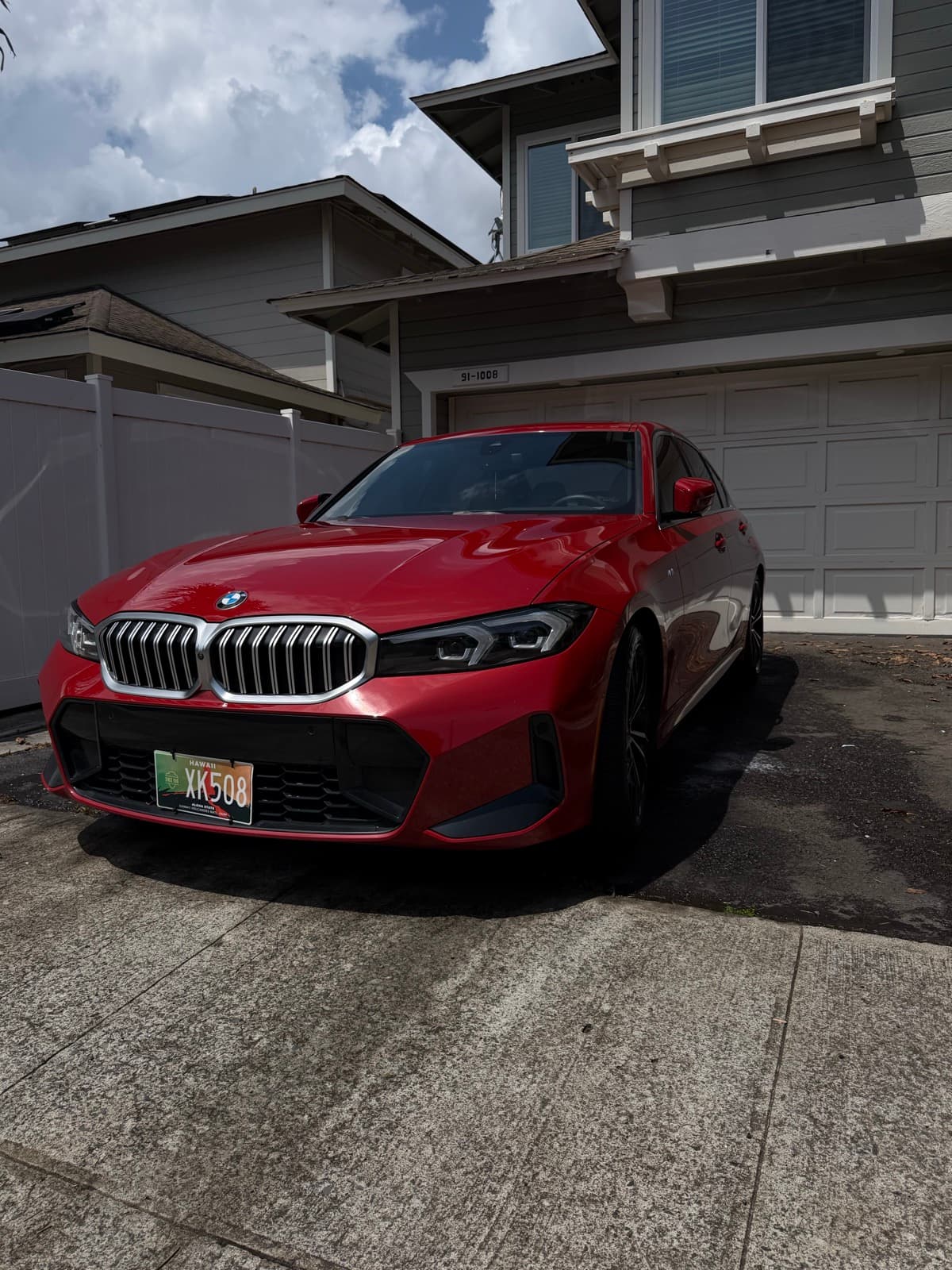 Red BMW X-Series SUV exterior detail in residential driveway — Manoa, Oahu Hawaii
