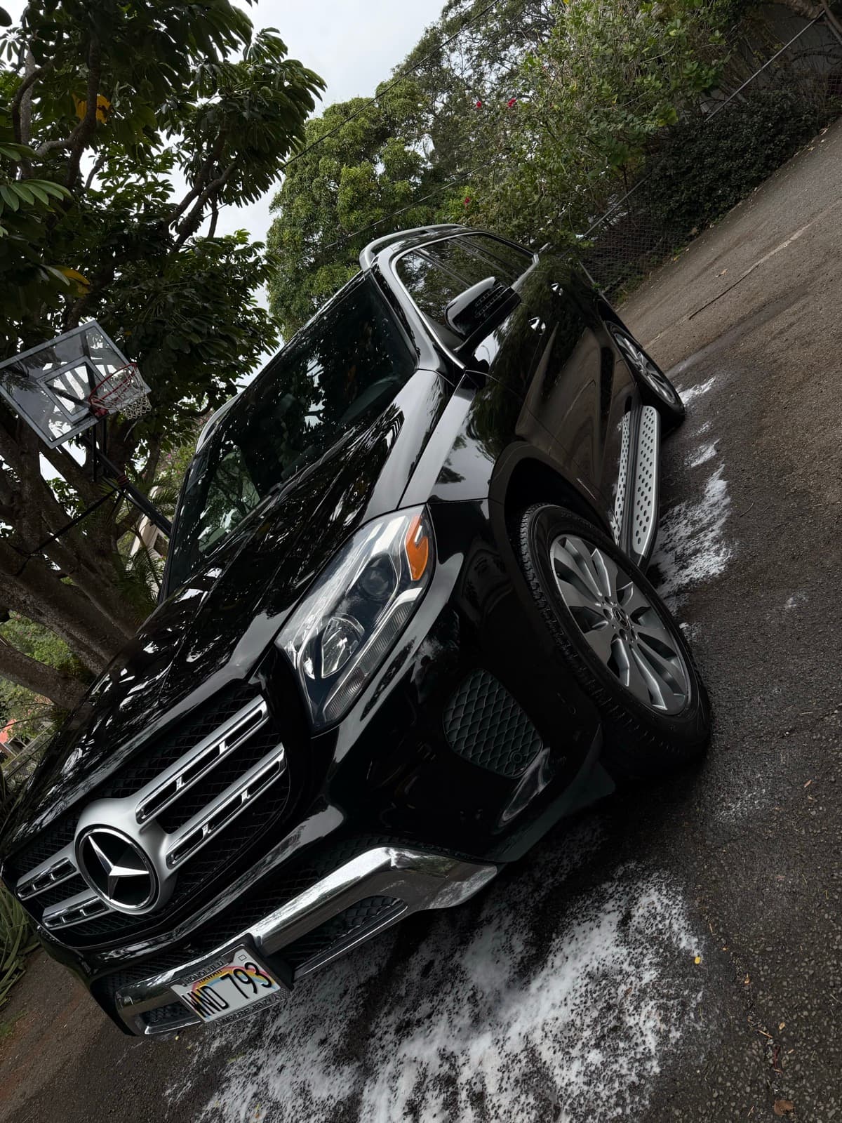 Black Mercedes-Benz GLE SUV exterior detail in tropical driveway — Kailua, Oahu Hawaii