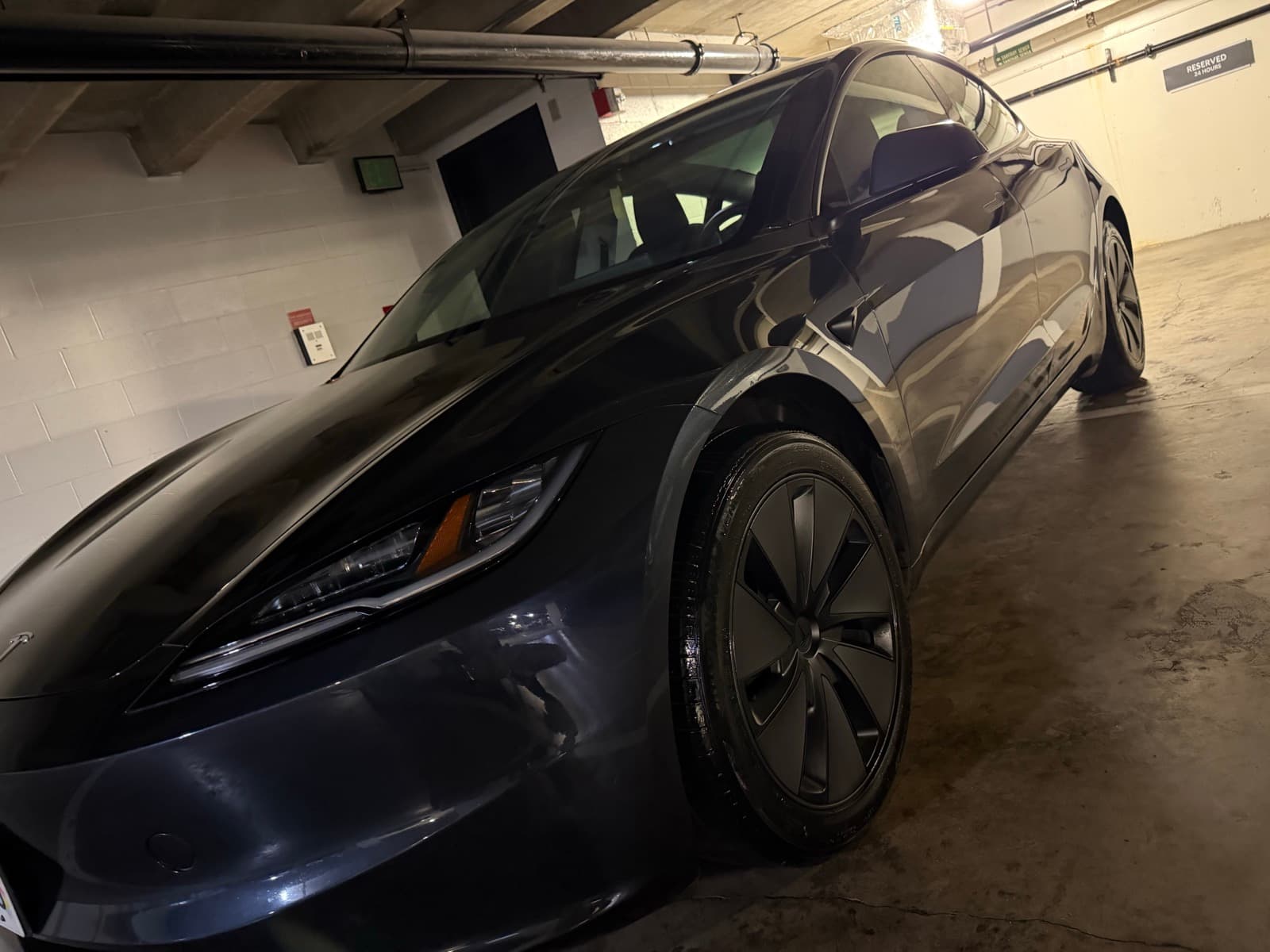 Dark Tesla Model 3 exterior detail — Honolulu condo parking garage, Oahu Hawaii